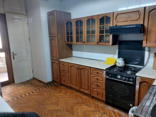 a kitchen with wooden cabinets and a stove top oven at A & F HOSTEL in Baku