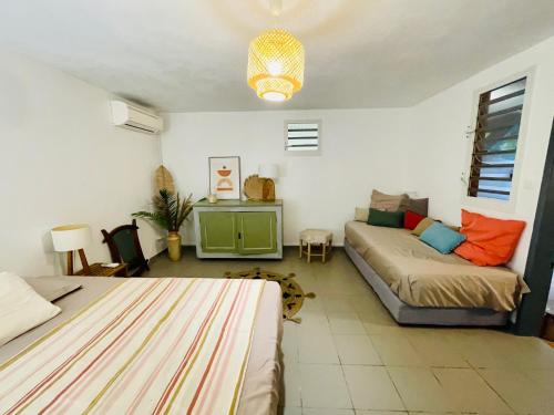 a living room with a bed and a couch at plage et spot de surf in Le Gosier