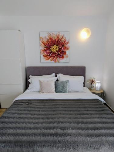 a bedroom with a large bed with a painting on the wall at King's Apartment in Baška