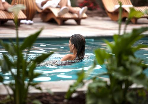 a woman is swimming in a swimming pool at Explora Valle Sagrado in Urubamba