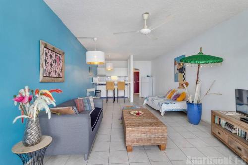 ein Wohnzimmer mit einem Sofa und einem Tisch in der Unterkunft Bonaire Oceanfront Apartments in Kralendijk