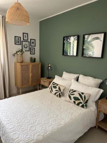 une chambre avec un grand lit blanc avec des oreillers dans l'établissement Au mas des glycines - Gîte La tropézienne - 5 personnes, à Camaret-sur-Aigues