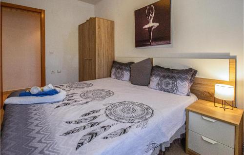 Schlafzimmer mit einem Bett mit einer schwarzen und weißen Bettdecke in der Unterkunft Gorgeous Apartment In Moraira With Outdoor Swimming Pool in Moraira