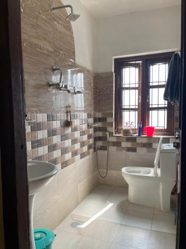 uma casa de banho com um WC e um lavatório em calmsutra em Catmandu