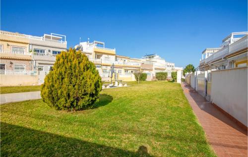 een groene tuin met een boom voor een gebouw bij 2 Bedroom Cozy Home In Orihuela in Orihuela