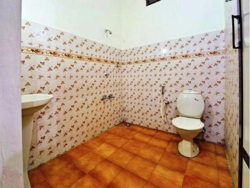 a bathroom with a toilet and a sink at Hotel Srinivas in Cochin