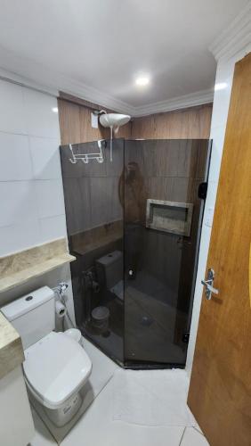 a bathroom with a toilet and a glass shower at FLAT Jardim de Alah - Frente Praia in Salvador