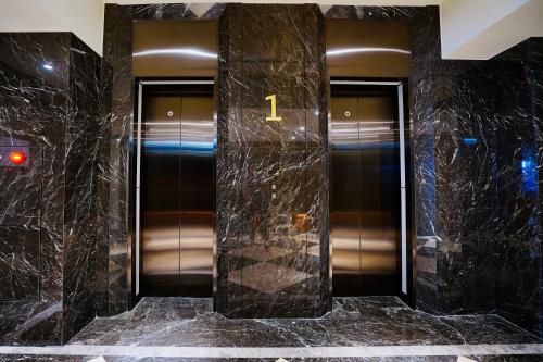 two elevators in a building with black marble at 龍江大飯店 in Shuili