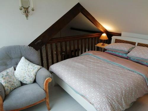 a bedroom with a bed and a chair at Converted rural stone cottage, Swansea in Swansea