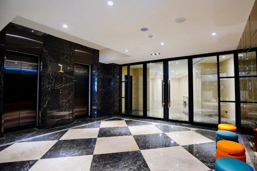 a lobby with a checkered floor and windows at 龍江大飯店 in Shuili