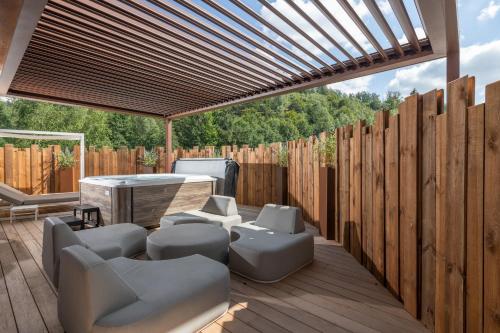 a patio with a table and chairs and a wooden fence at LA CHENEAUDIÈRE - Hôtel Spa - Relais & Châteaux - Restaurant étoilé in Colroy-la-Roche