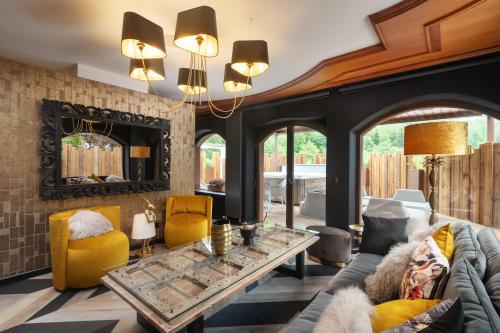 a living room with a couch and a table at LA CHENEAUDIÈRE - Hôtel Spa - Relais & Châteaux - Restaurant étoilé in Colroy-la-Roche