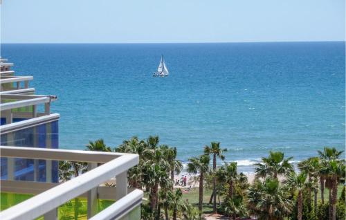 a sailboat in the ocean with palm trees and a beach at Cozy Apartment In Oropesa Del Mar in Oropesa del Mar
