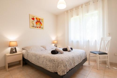 1 dormitorio con 1 cama, 1 silla y 1 ventana en Costebelle Vue Mer 2ch/4p Terrasse Garage privatif en Hyères