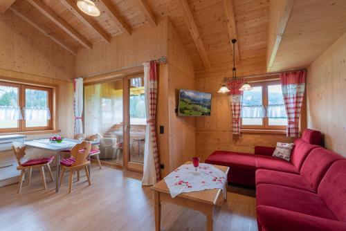 a living room with a red couch and a table at Ferienwohnungen Weiler in Oberstdorf