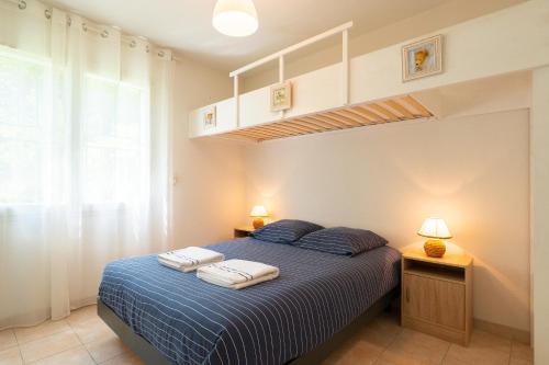 une chambre avec un lit avec deux serviettes dessus dans l'établissement La Clé Vue Mer, Clim, Terrasse, Parking à Hyères, à Hyères