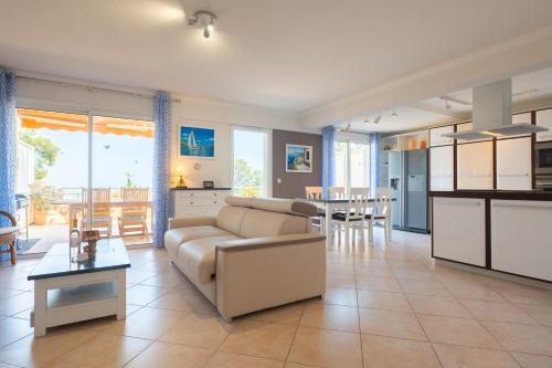 uma grande sala de estar com um sofá e uma mesa em Costebelle Vue Mer 2ch/4p Terrasse Garage privatif em Hyères