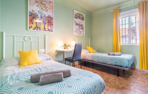 1 dormitorio con 2 camas, mesa y escritorio en Awesome Home In Alfarnate With Kitchen en Alfarnatejo