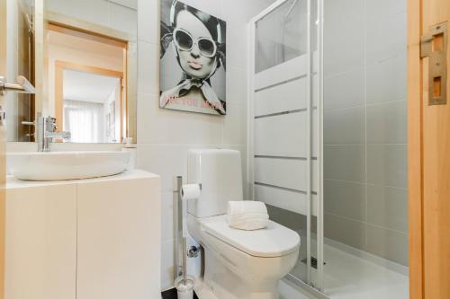 uma casa de banho com um WC, um lavatório e um espelho. em D João IV Apartment With Terrace by LovelyStay no Porto