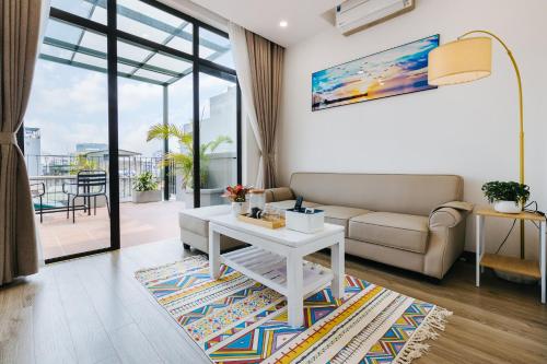 a living room with a couch and a table at LUCK APART 9 - Hanoi WestLake Balcony Apartment in Hanoi