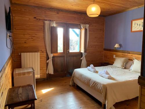 1 dormitorio con 1 cama en una habitación con ventana en Hosteria Hainen en El Calafate