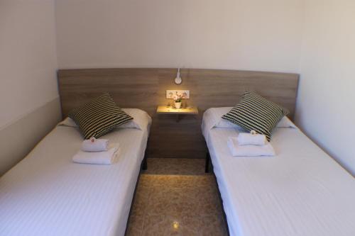 ロザスにあるAgi La Pintaのサイドテーブル付きの小さな部屋のツインベッド2台