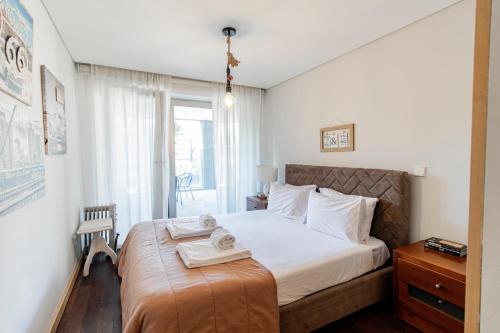 um quarto com uma cama com duas toalhas em D João IV Apartment With Terrace by LovelyStay no Porto