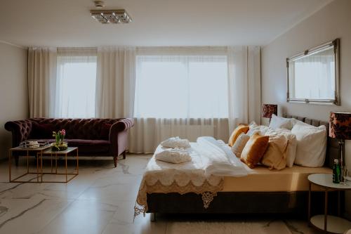a bedroom with a large bed and a couch at Hotel Greys Polonia in Zasutowo