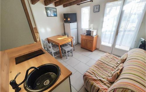 Il comprend un salon doté d'un canapé et une cuisine équipée d'un évier. dans l'établissement 2 Bedroom Stunning Home In Marseillan, à Marseillan