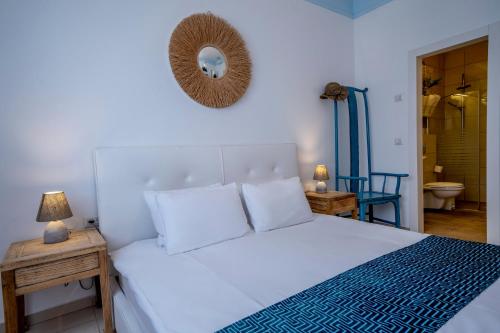 una camera con un letto bianco e uno specchio a parete di הבית על ההר - Ella Sun a Eilat