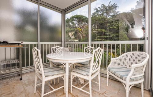 une véranda avec une table, des chaises et une fenêtre dans l'établissement Beautiful Apartment In Cannes With Wifi, à Cannes
