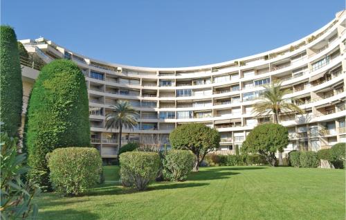 un grand immeuble avec une pelouse et des arbres dans l'établissement 2 Bedroom Amazing Apartment In Cannes, à Cannes