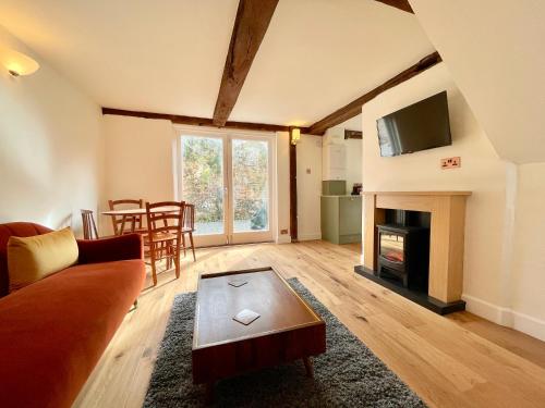 a living room with a couch and a fireplace at Abbey Gardens Cottage in Bury Saint Edmunds