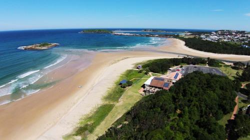 an aerial view of a beach and the ocean at Beachlander Self-Contained Holiday Apartments in Coffs Harbour