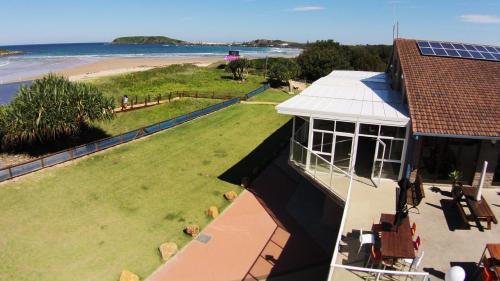an aerial view of a house with a view of the beach at Beachlander Self-Contained Holiday Apartments in Coffs Harbour