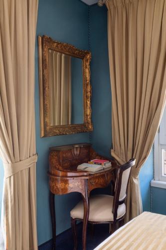 a bedroom with a desk and a mirror and curtains at Hotel Scalinata Di Spagna in Rome