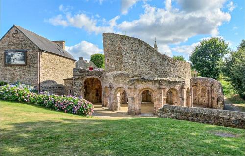 an old stone building with flowers in the yard at Lovely Home In Tréméven With Wifi in Trémeven