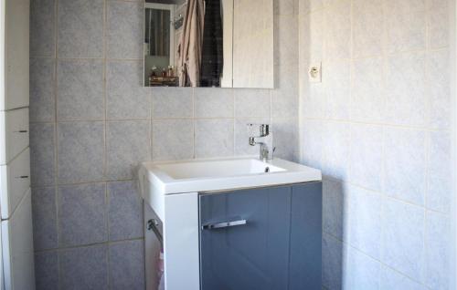 La salle de bains est pourvue d'un lavabo et d'un miroir. dans l'établissement Lovely Home In Trmven With Wifi, à Trémeven