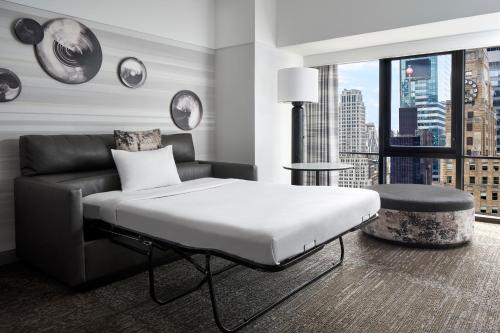 a bedroom with a bed and a couch and a window at New York Marriott Marquis in New York