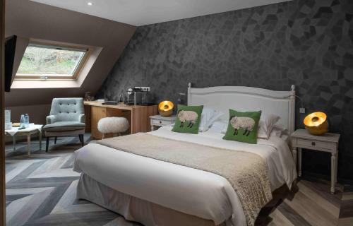 a bedroom with a large white bed with green pillows at LA CHENEAUDIÈRE - Hôtel Spa - Relais & Châteaux - Restaurant étoilé in Colroy-la-Roche