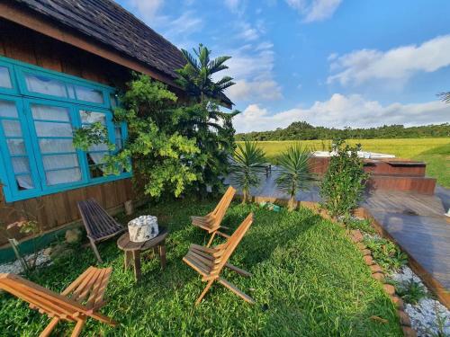 a group of chairs and a table in front of a house at Chalé Sol com hidromassagem em meio a natureza in Piçarras