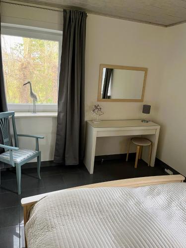 a bedroom with a bed and a desk and a window at Wunderschönes Ferienhaus in Strandnähe in Retranchement