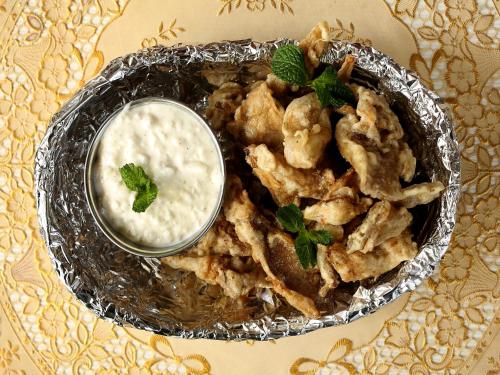 a plate of food with a bowl of dipping sauce at Hotel Pleasure Home in Kathmandu