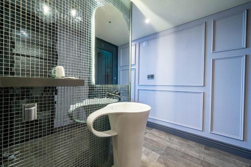 a bathroom with a white sink and a mirror at Sokcho Business Hotel CAMEL in Sokcho