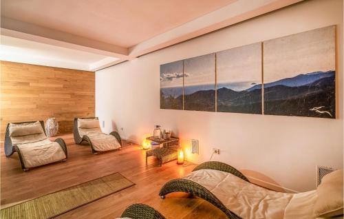 a living room with chairs and a bed and a painting at Beautiful Apartment In Magliolo With Outdoor Swimming Pool, Sauna And 1 Bedrooms in Magliolo