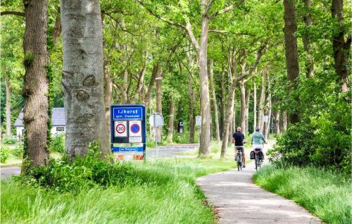 two people riding bikes down a path with trees at Gorgeous Home In Ijhorst With Wifi in IJhorst