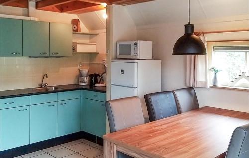 uma cozinha com uma mesa e um frigorífico branco em Gorgeous Home In Ijhorst With Wifi em IJhorst