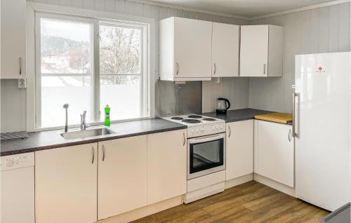 una cucina con armadi bianchi, lavandino e frigorifero di Lovely Apartment In Mesnali With Kitchen a Mesnali
