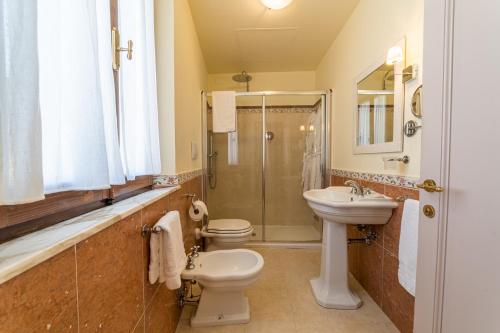 a bathroom with a toilet and a sink and a shower at La Locanda Di San Francesco in Montepulciano