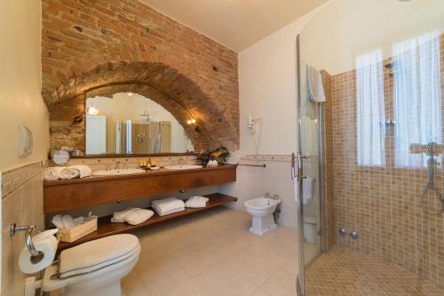 a bathroom with a sink toilet and a mirror at La Locanda Di San Francesco in Montepulciano